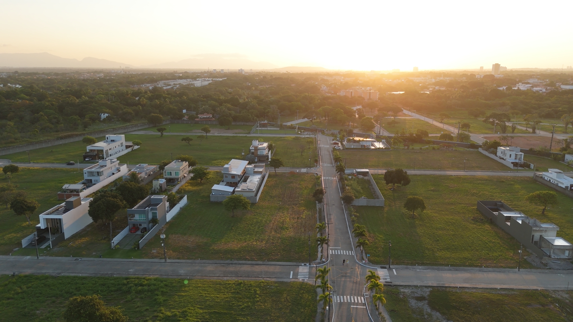 Vista aérea das casas e lotes ao pôr do sol